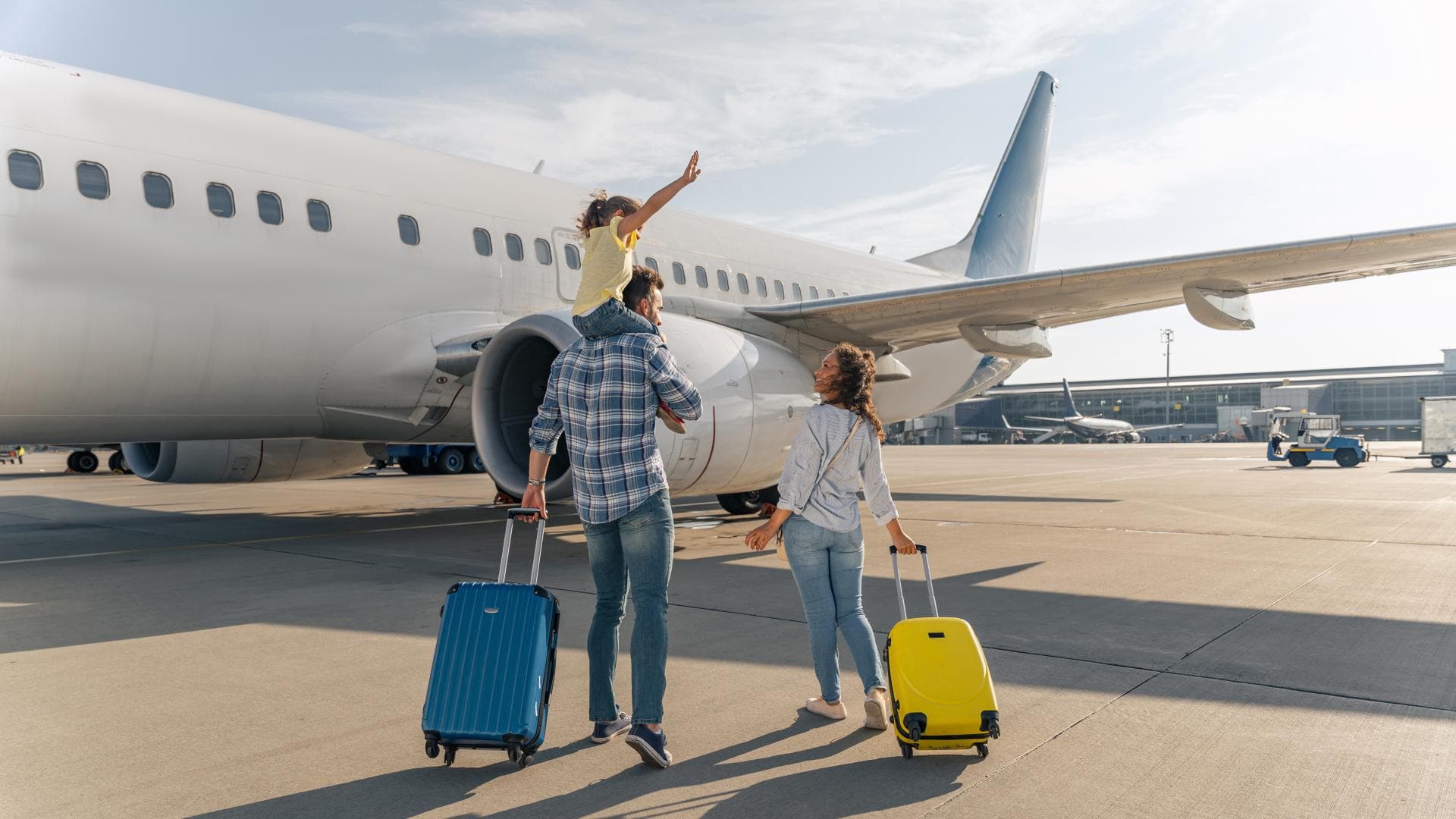 Familie mit schulpflichtigem Kind am Flughafen.