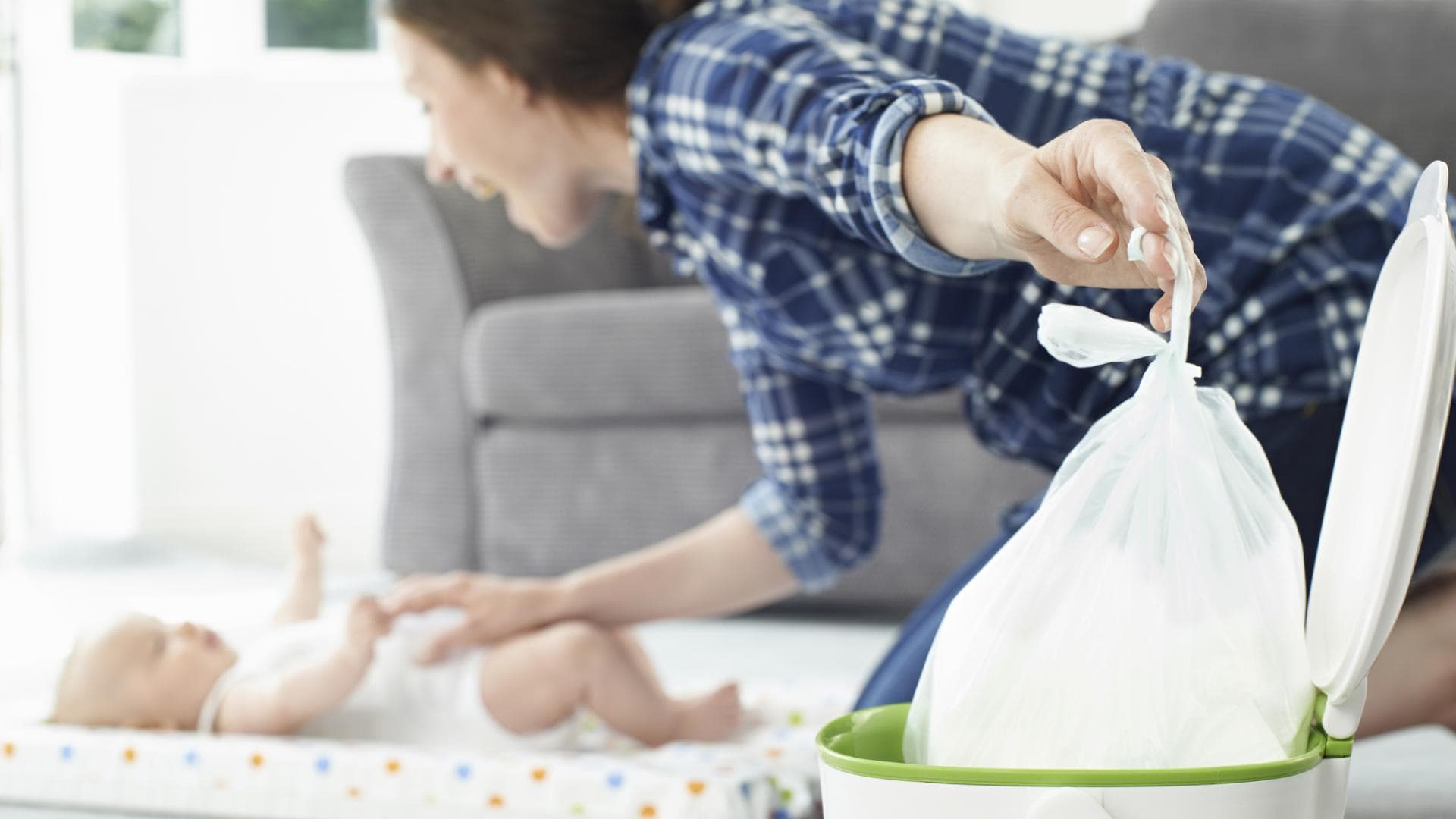 Mama wirft Windel in geruchsdichten Windeleimer Mama wirft Windel in geruchsdichten Windeleimer