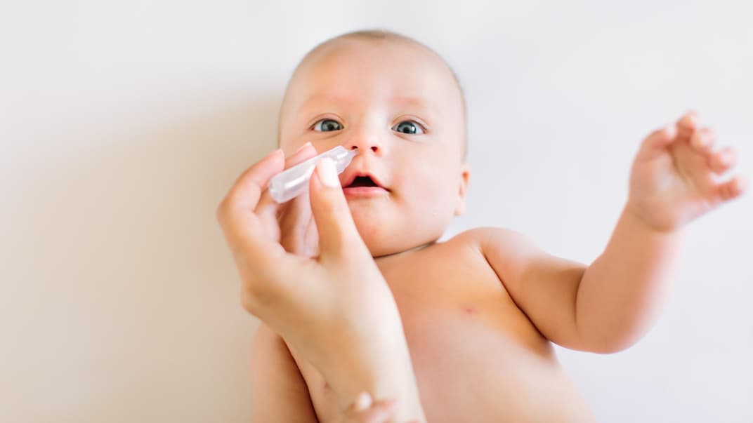 Baby bekommt Nasentropfen in die Nase geträufelt