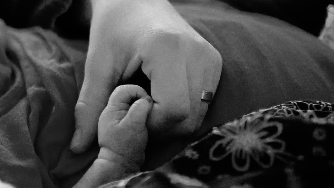 Frau hält Hand ihres Babys