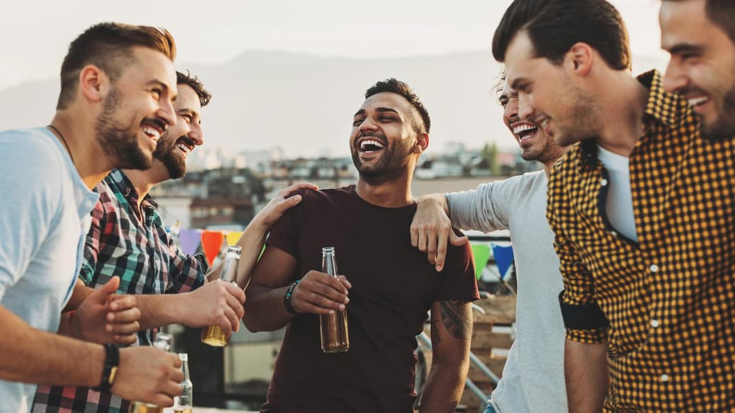 Männer lachen und trinken Bier