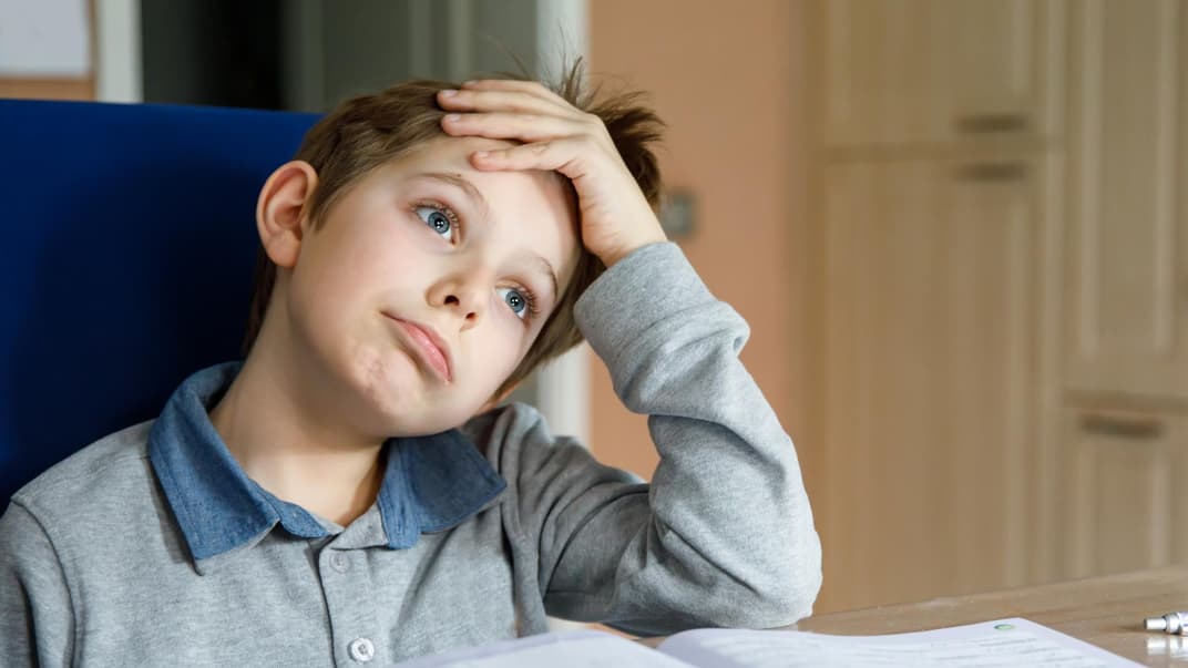 Junge angestrengt bei den Hausaufgaben