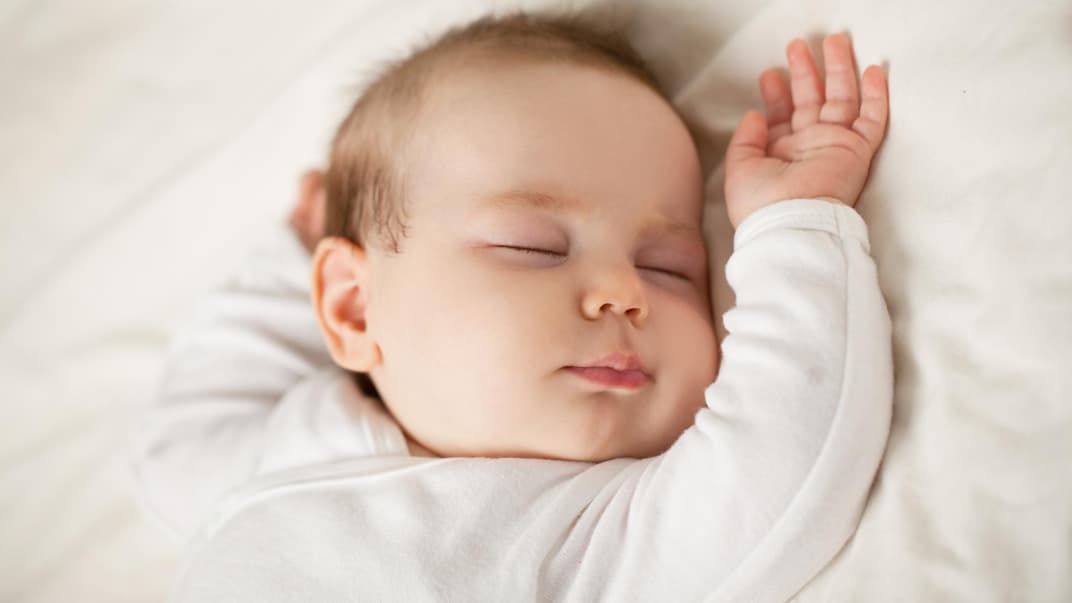 Ein Baby schläft in seinem Bett.