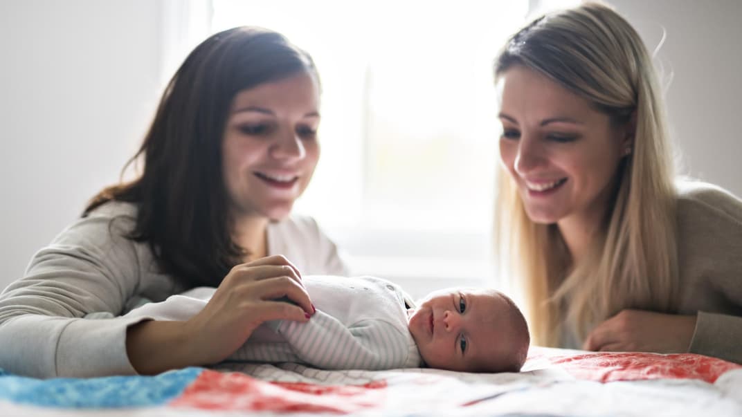 Ein Säugling und zwei Frauen