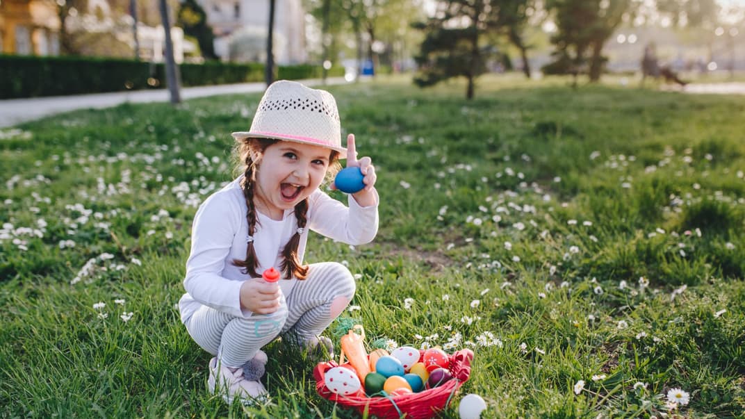 Ein Mädchen zeigt stolz sein Osternest
