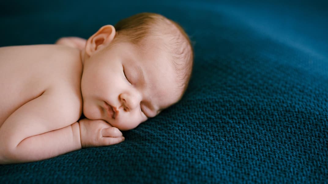 Wenn sich das Baby nachts auf den Bauch dreht, sorgen sich viele Eltern. Ein Baby schläft in Bauchlage.