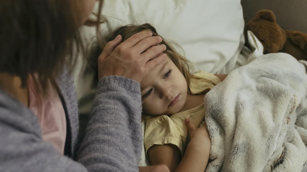 Mutter fühlt ihrem Kind die Stirn