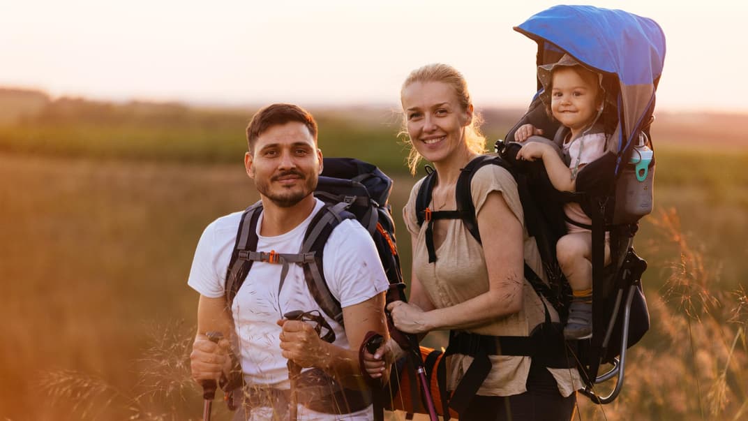 Familie beim Wandern mit der Kraxe