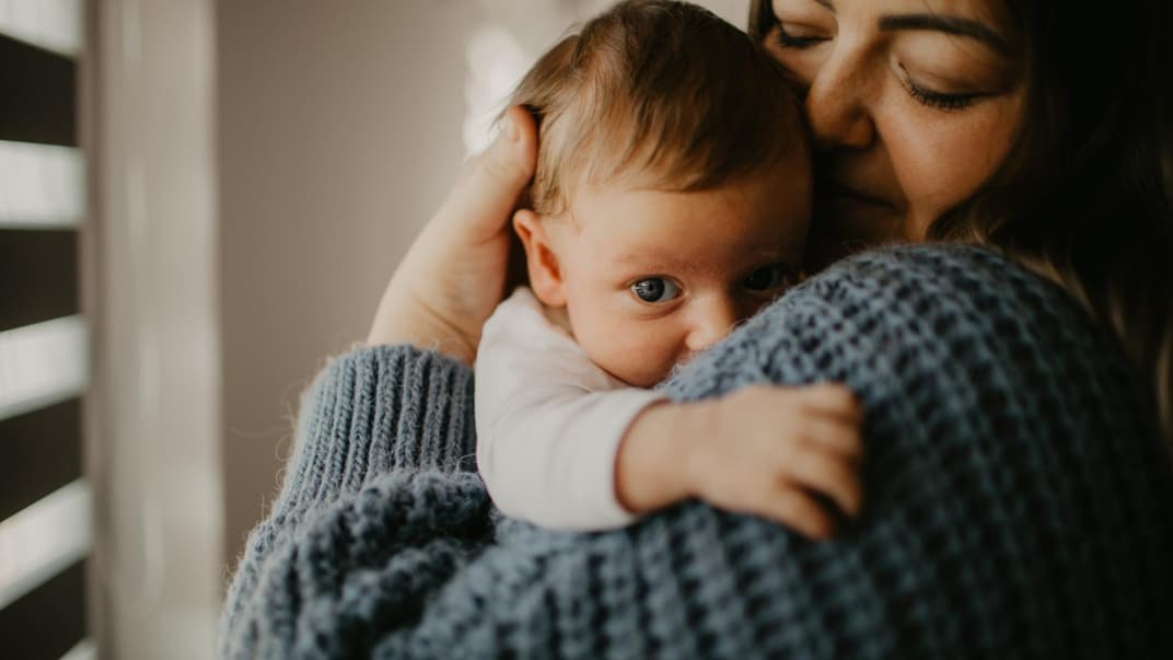 Neugeborener Junge auf dem Arm seiner Mama