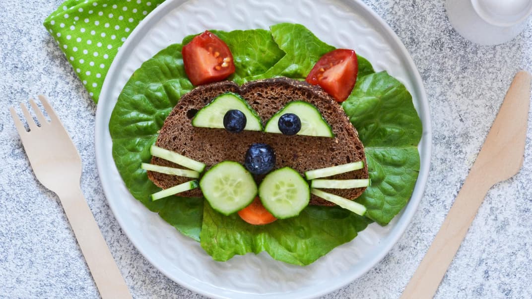 Ein Katzengesicht aus Brot, Obst und Gemüse