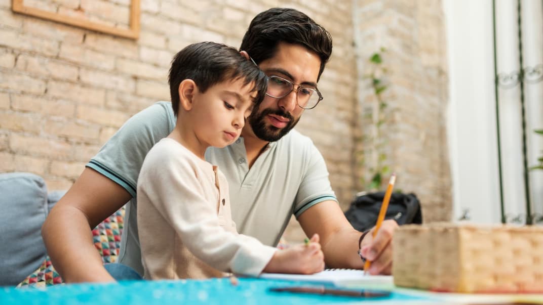 Ein Vater malt mit seinem Kind Tierbilder