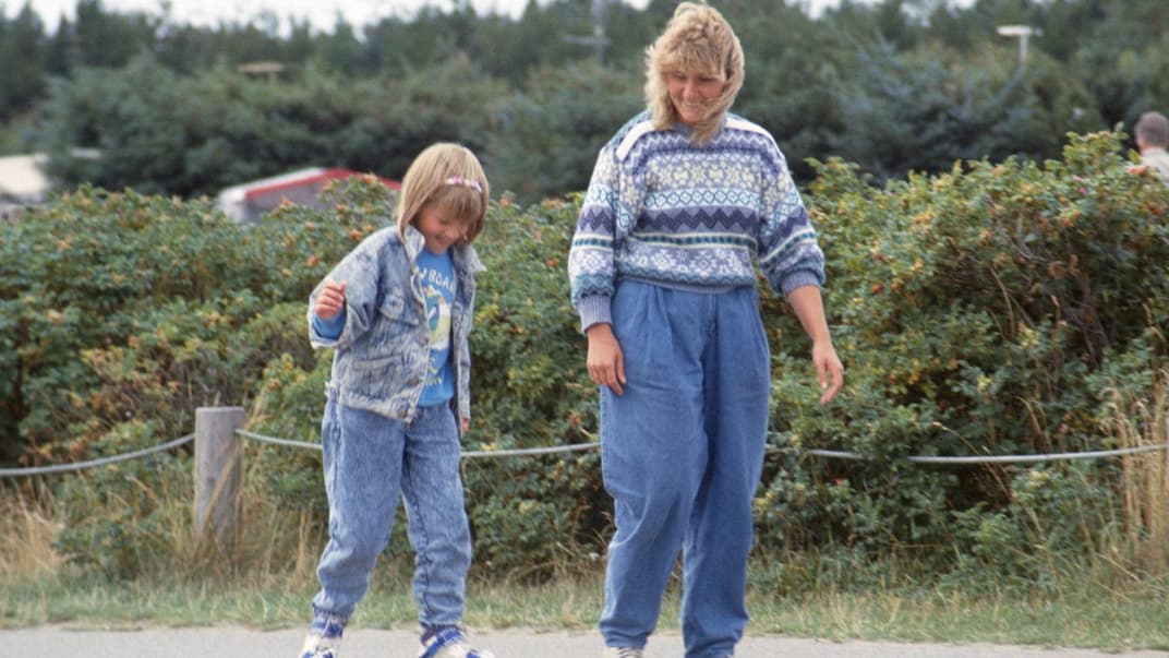 Mutter und Kind fahren Rollschuh.