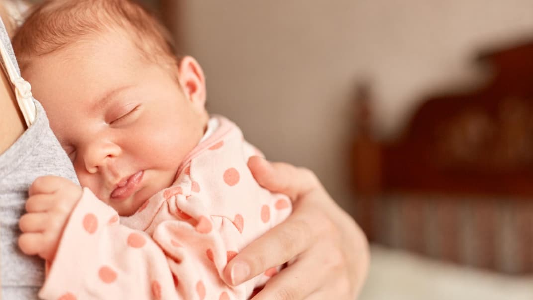 Neugeborenes Baby kuschelt auf dem Arm seiner Mutter. 