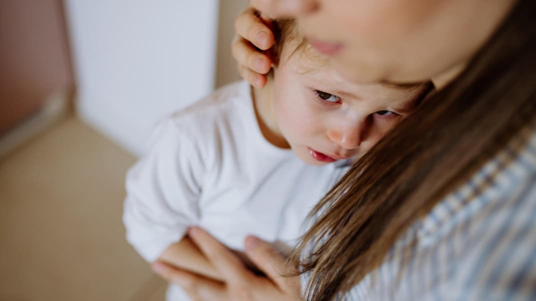 Junge weint beim Abschied von seiner Mutter.