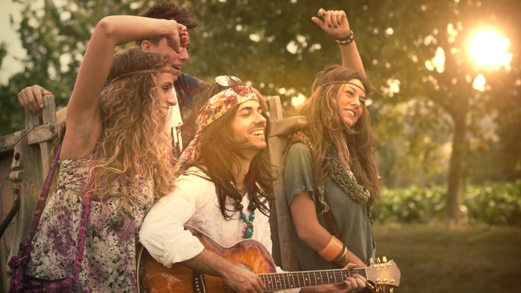 Eine Gruppe junger Hippies lacht und tanzt.