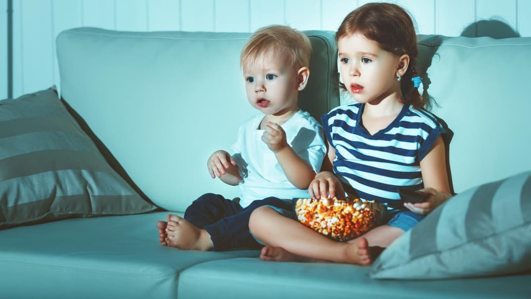 Zwei Kinder sitzen auf dem Sofa