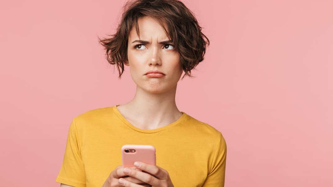 Mutter schaut genervt auf ihr Handy