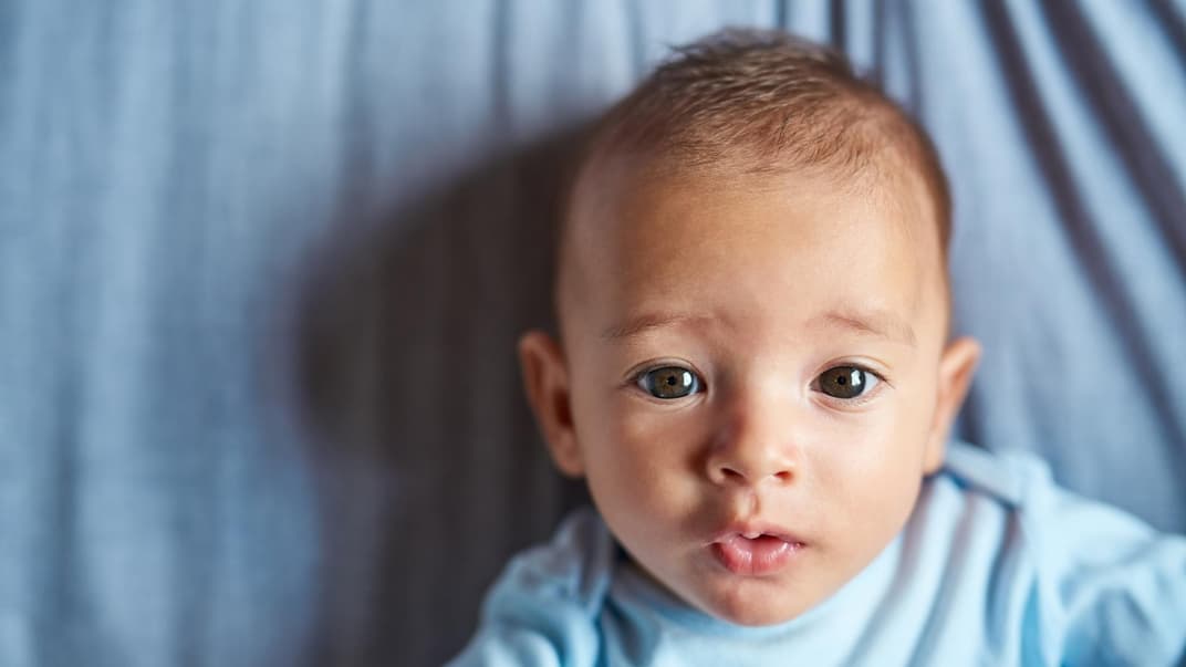 Ein kleines Baby, das süß in die Kamera guckt. 