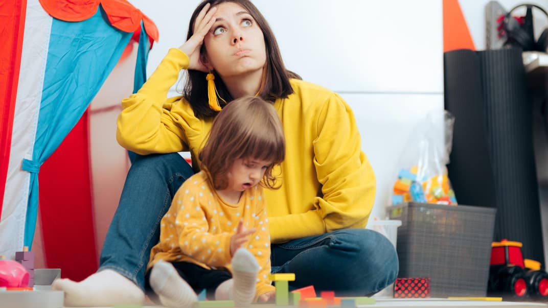 Genervte Mutter mit spielender Tochter.