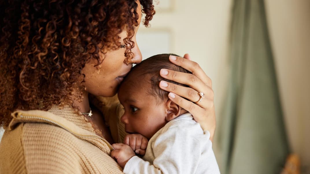 Mutter küsst ihr Baby. 