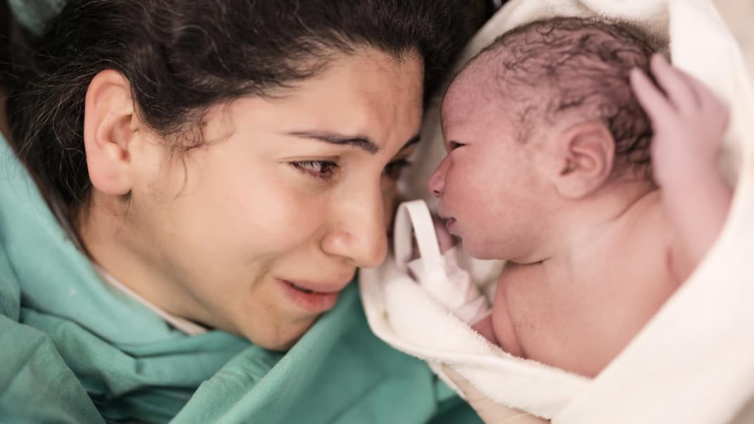 Eine Frau direkt nach der Geburt mit ihrem Baby