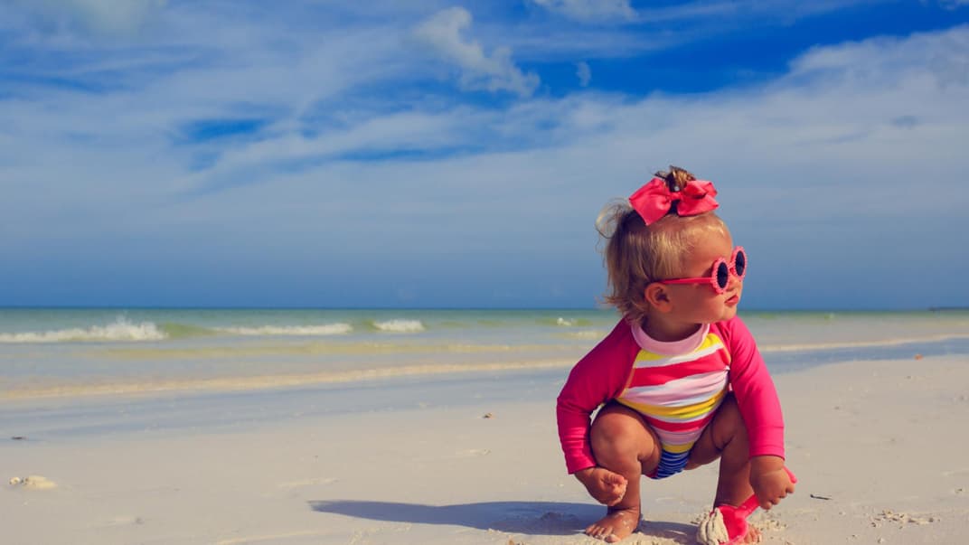Ein kleines Mädchen spielt am Strand.