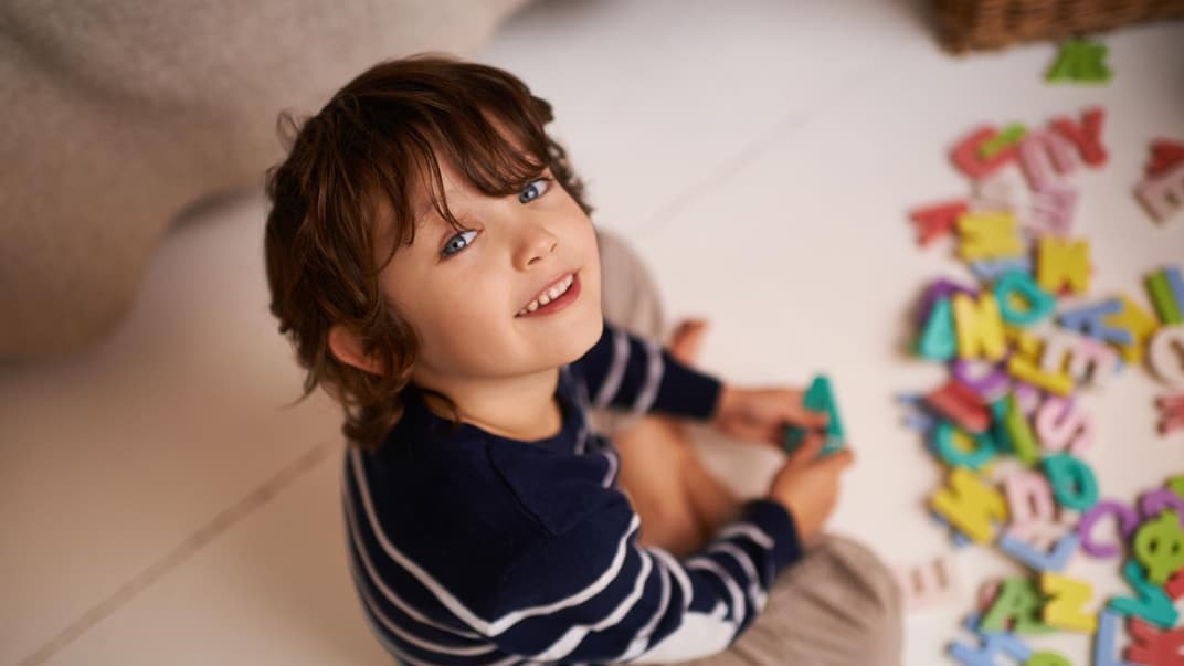 Kind spielt mit Buchstaben.