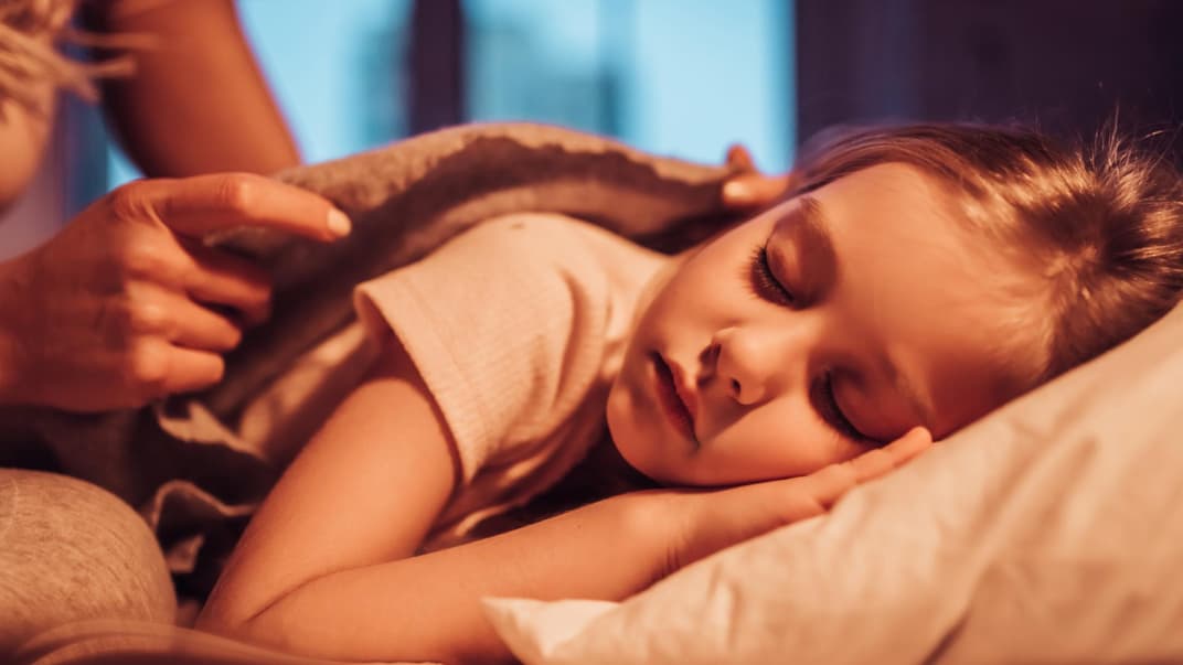 Mutter bringt ihre Tochter ins Bett