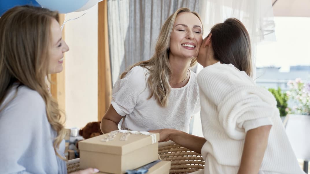 Freundinnen überreichen frisch gebackener Mutter Geschenke