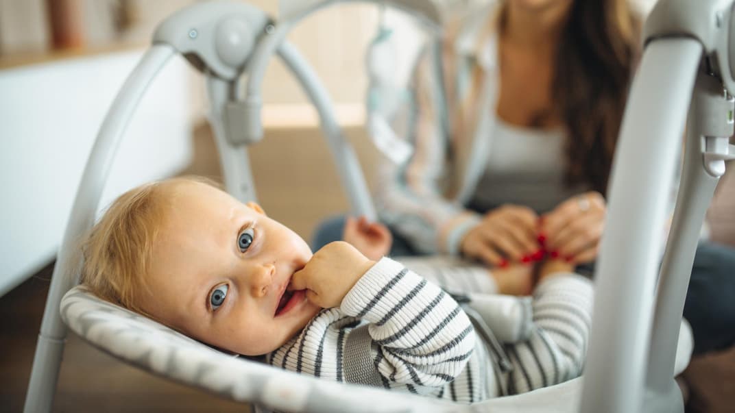 Baby liegt in Babywippe