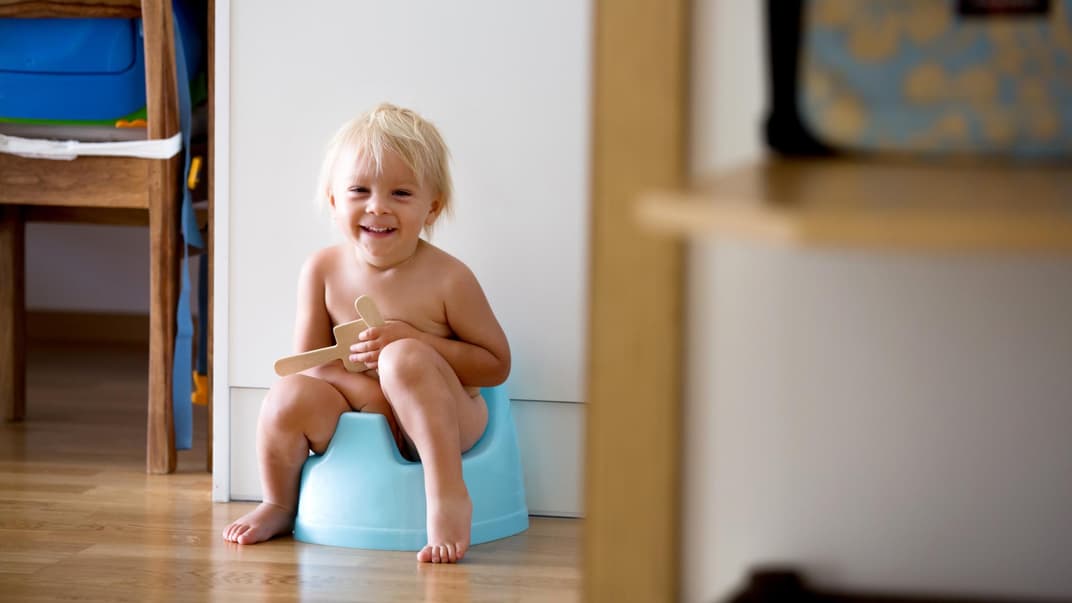 Junge sitzt auf Töpfchen mit Musik