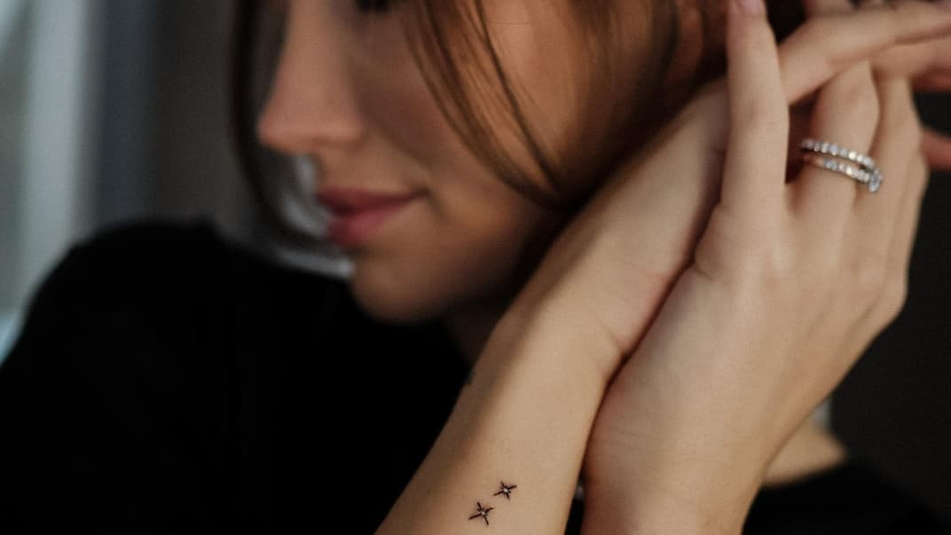 Anna Adamyan zeigt ihre Stern-Tattoos.
