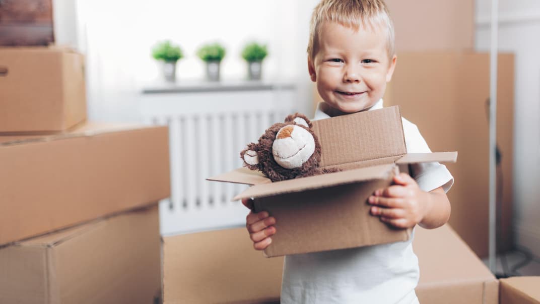 Junge trägt Umzugskiste.