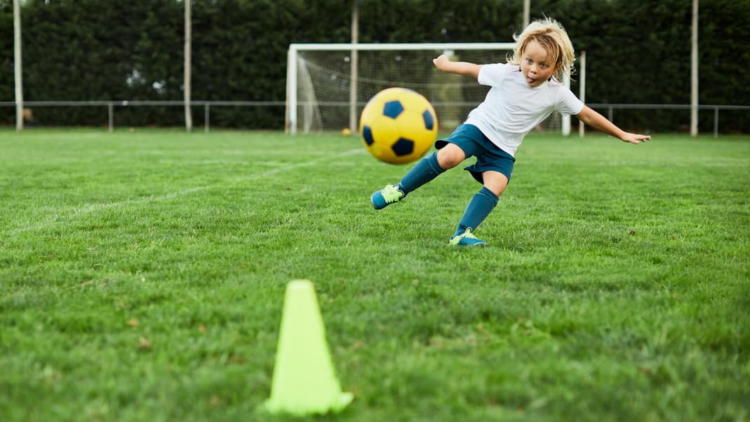 Eine Junge schießt einen Fußball