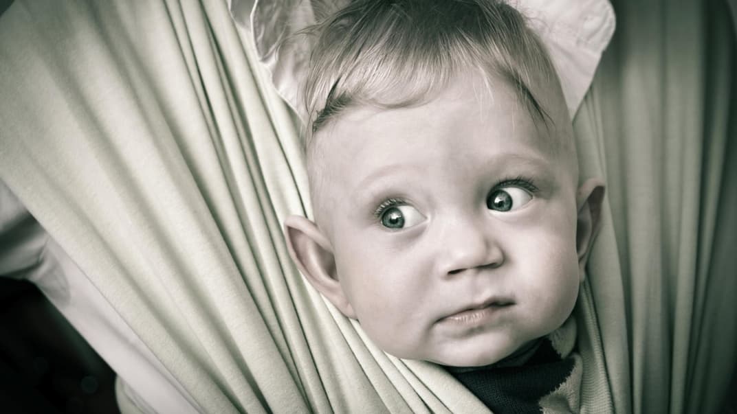 Herr der Ringe: Kleiner Elben-Junge guckt lustig aus der Babytrage heraus. 