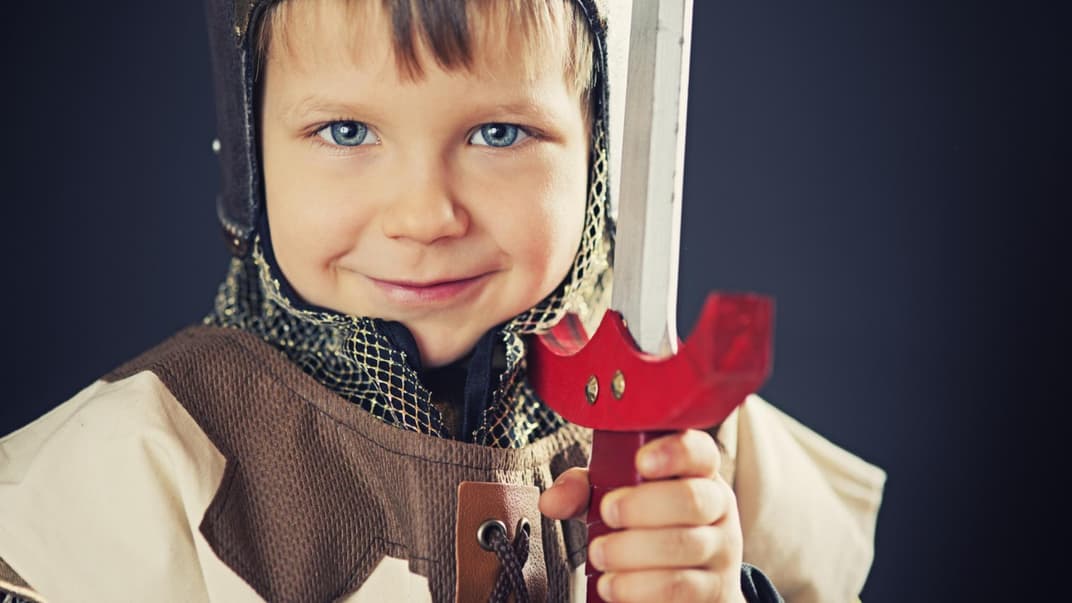 Kleiner Junge ist als Game-of-Thrones-Ritter verkleidet und lacht