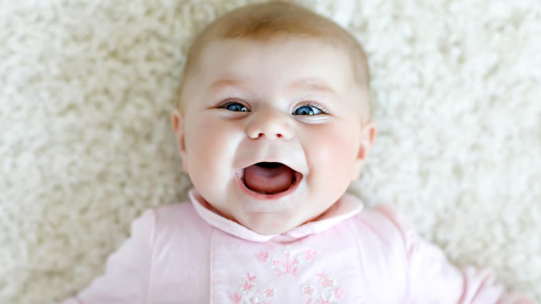Baby-Mädchen mit biblischem Namen lacht fröhlich in die Kamera. 
