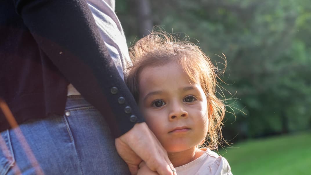 Mädchen an der Hand ihrer Mutter.