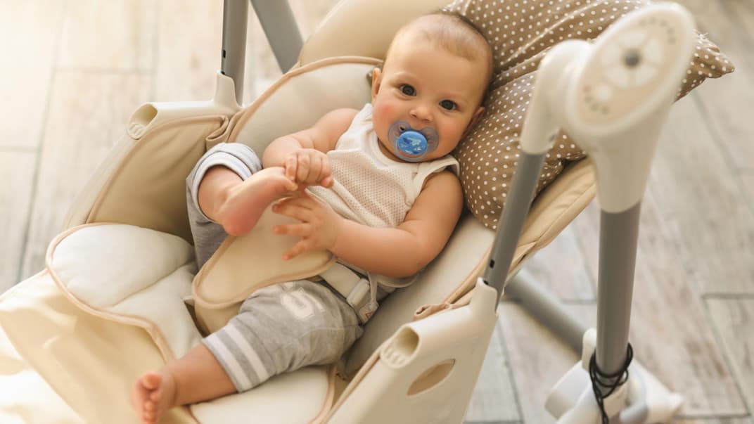 Baby liegt in Babyschaukel