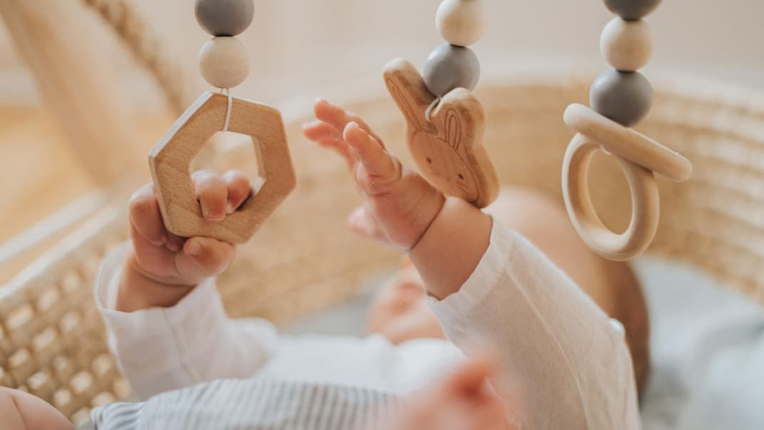 Baby spielt mit Holz-Mobile