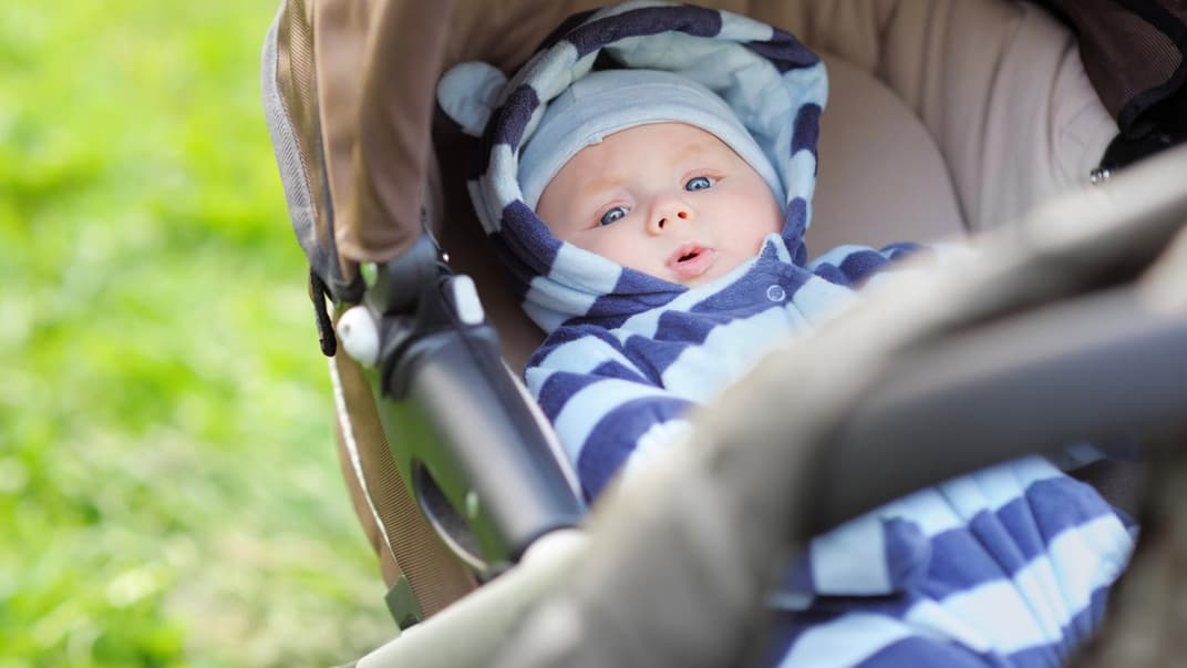 Baby liegt im Kinderwagen