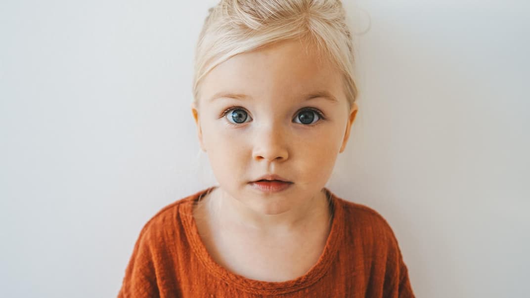 Blondes Mädchen schaut in die Kamera.