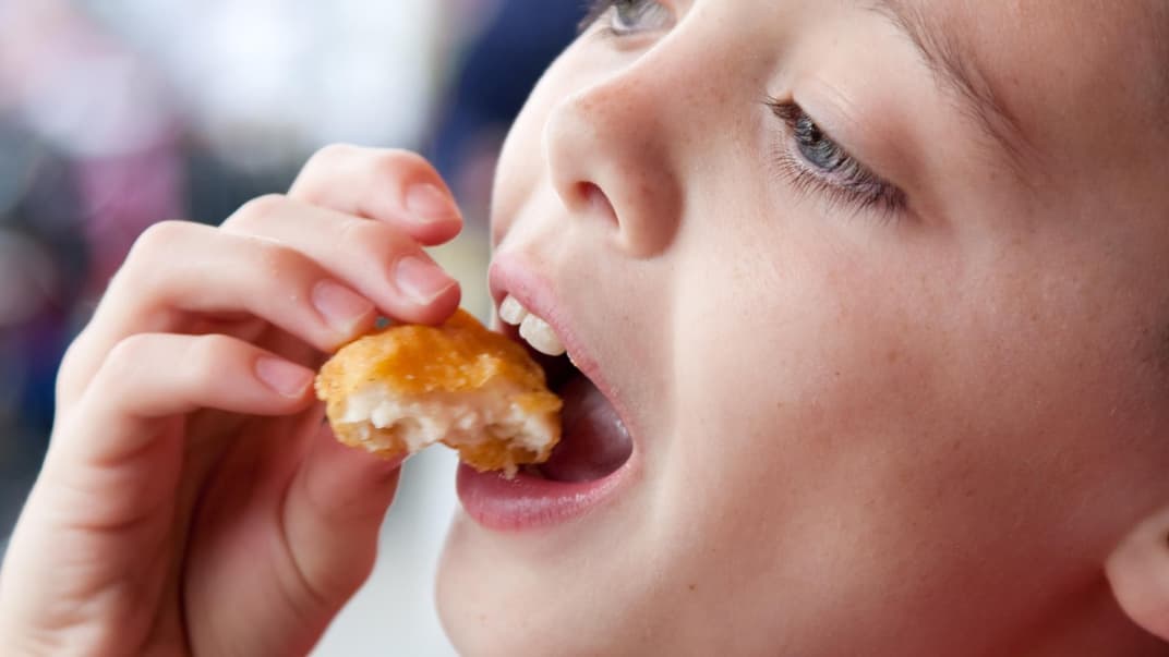 Junge isst Chicken Nuggets.
