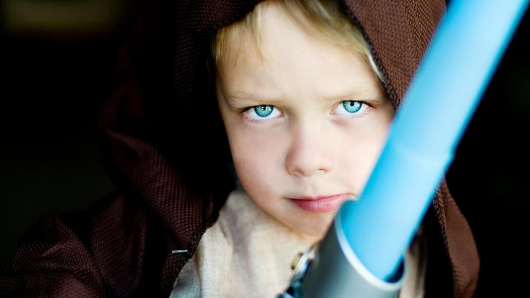 Ein Junge ist als Jedi-Ritter verkleidet.