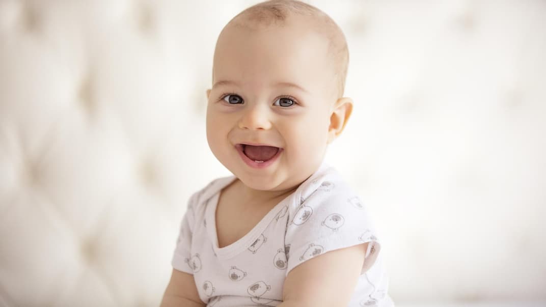 Lachendes Baby im Sitzen.