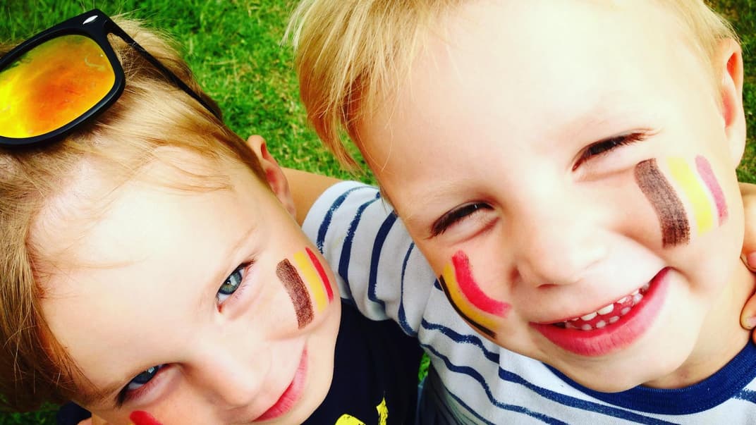 Zwei belgische Kinder mit aufgemalter Flagge auf den Wangen