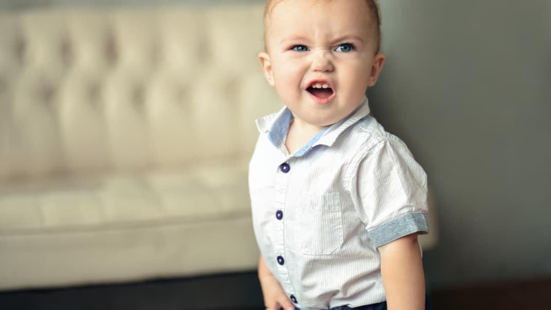 Kleiner Baby-Junge rümpft die Nase und schaut keck in die Gegend. 