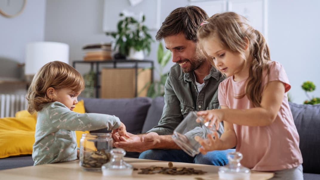 Papa und Kinder zählen Geld.