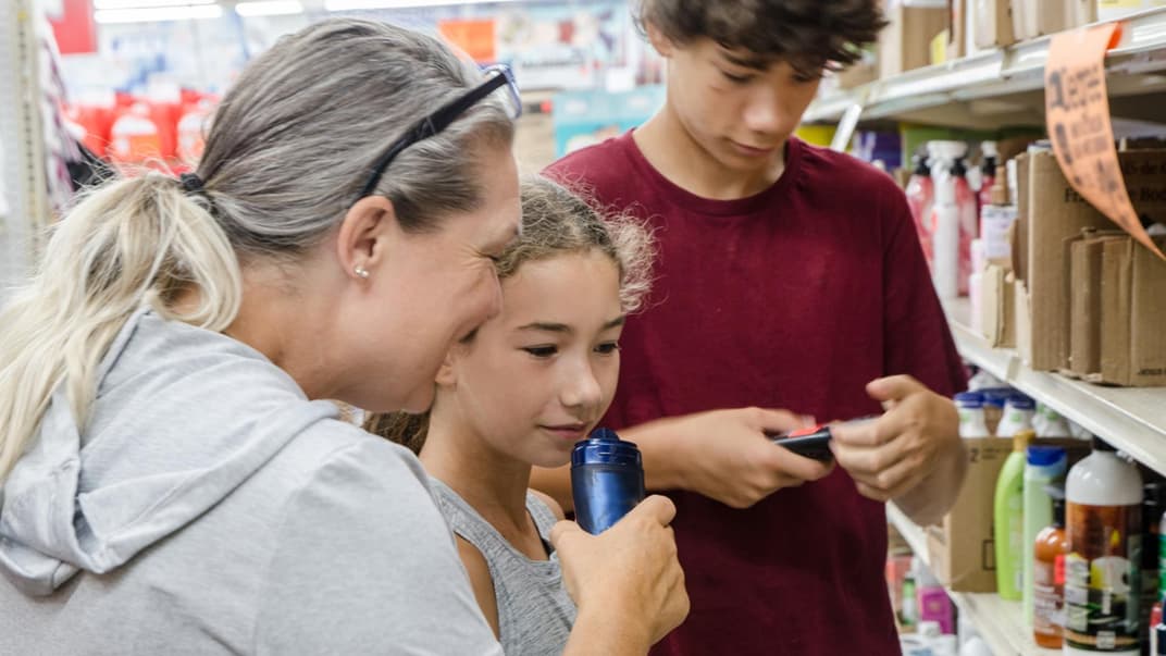 Mutter sucht mit ihren Kindern ein Deo aus.