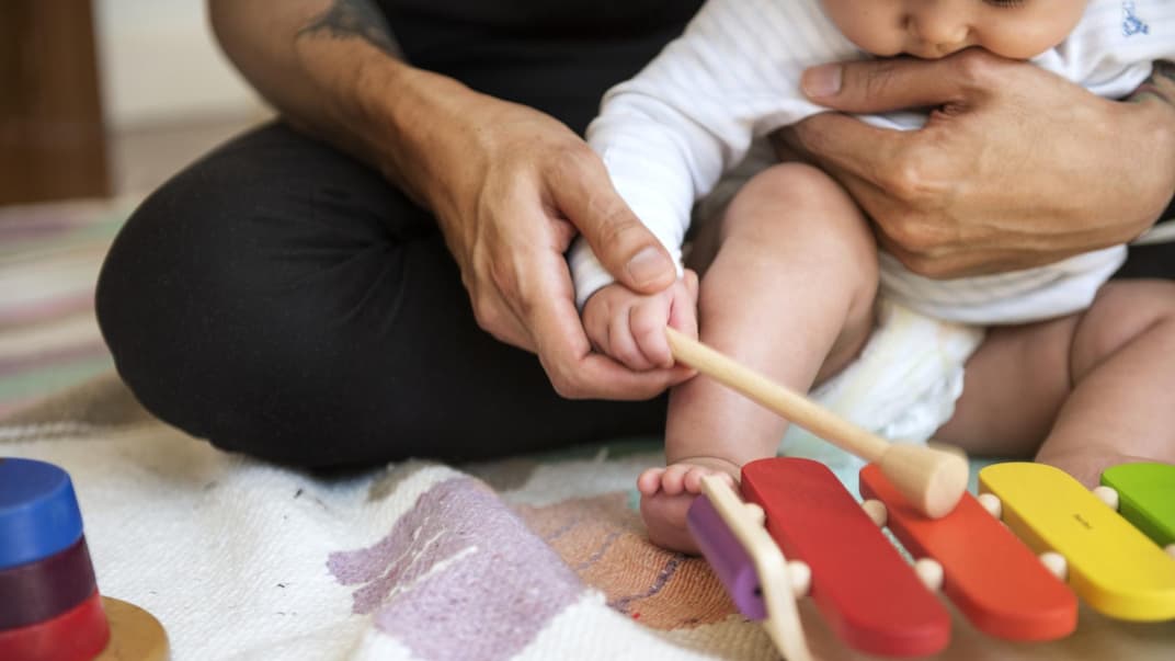 Vater übt mit seinem Baby Xylophon-Spielen
